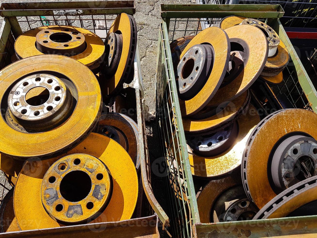 Old rusted car brake discs in the junkyard photo