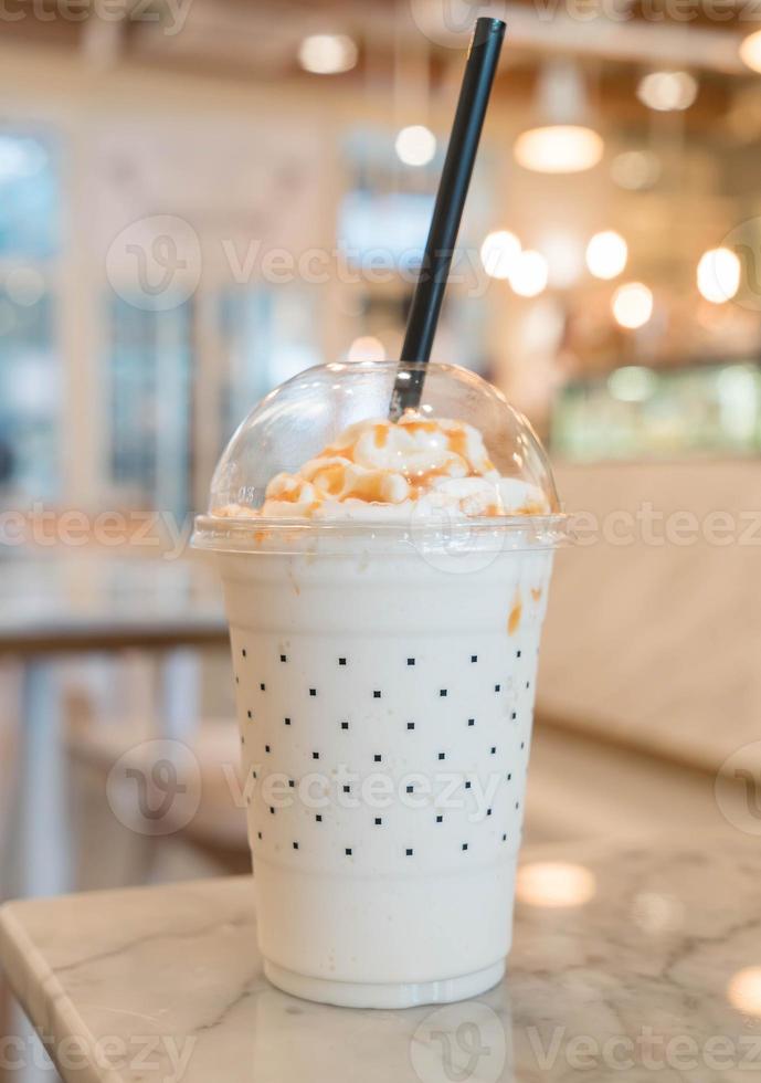 Caramel milkshake on the table in cafe photo