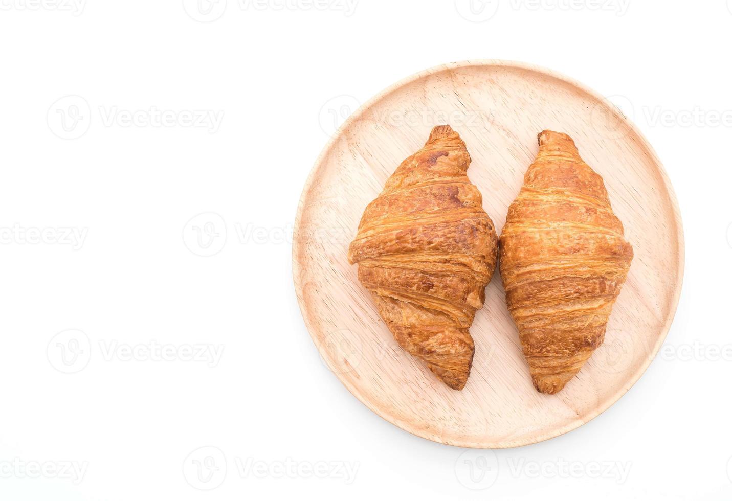 Croissant de mantequilla sobre fondo blanco. foto