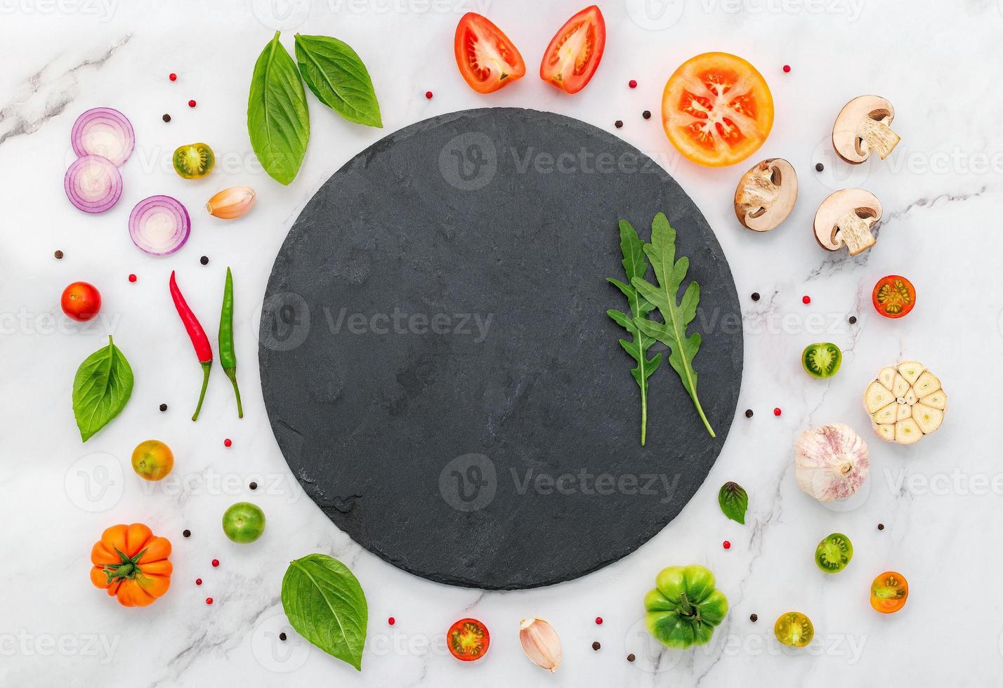 The ingredients for homemade pizza set up on white marble background photo