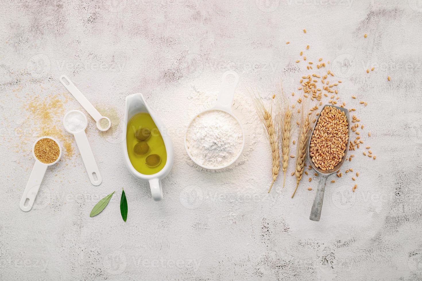 The ingredients for homemade pizza dough on white concrete background photo