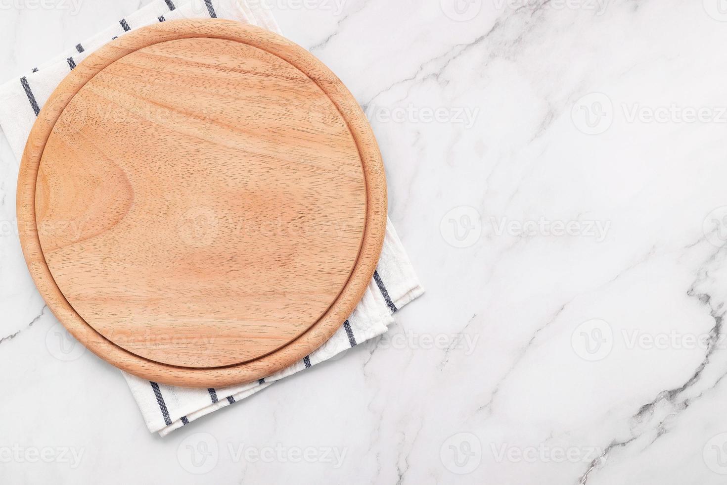 Plato de pizza de madera vacía con servilleta sobre piedra de mármol foto