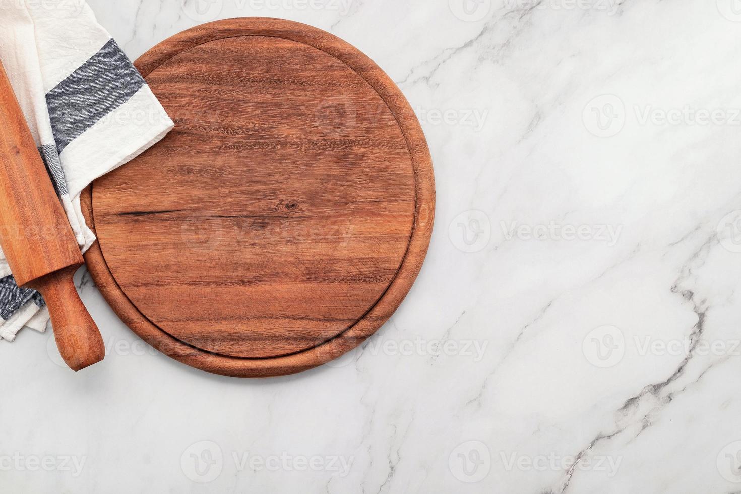 Empty wooden pizza platter with napkin  set up on marble stone photo