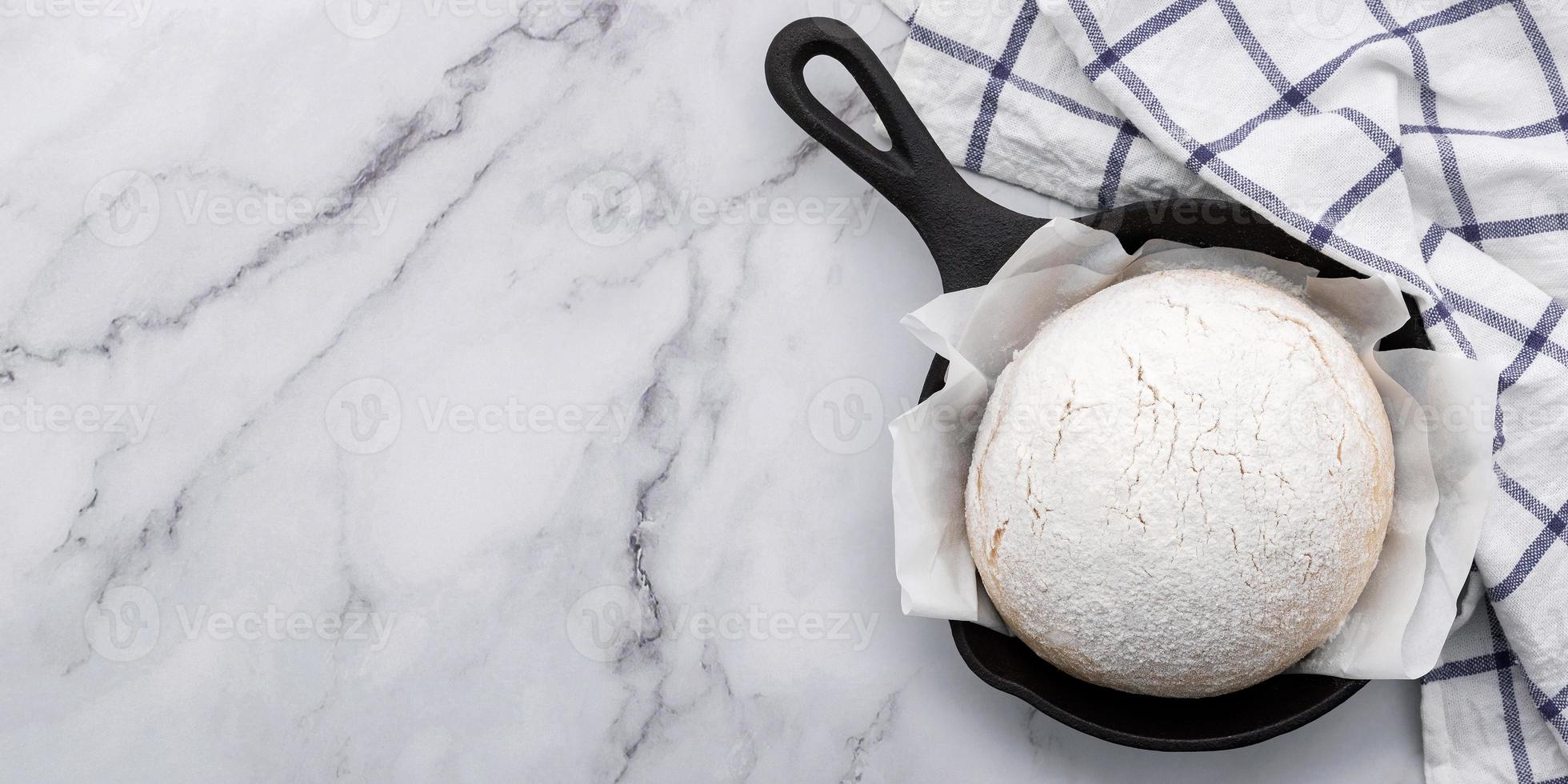 Masa de levadura casera cruda fresca descansando en una sartén de hierro fundido foto