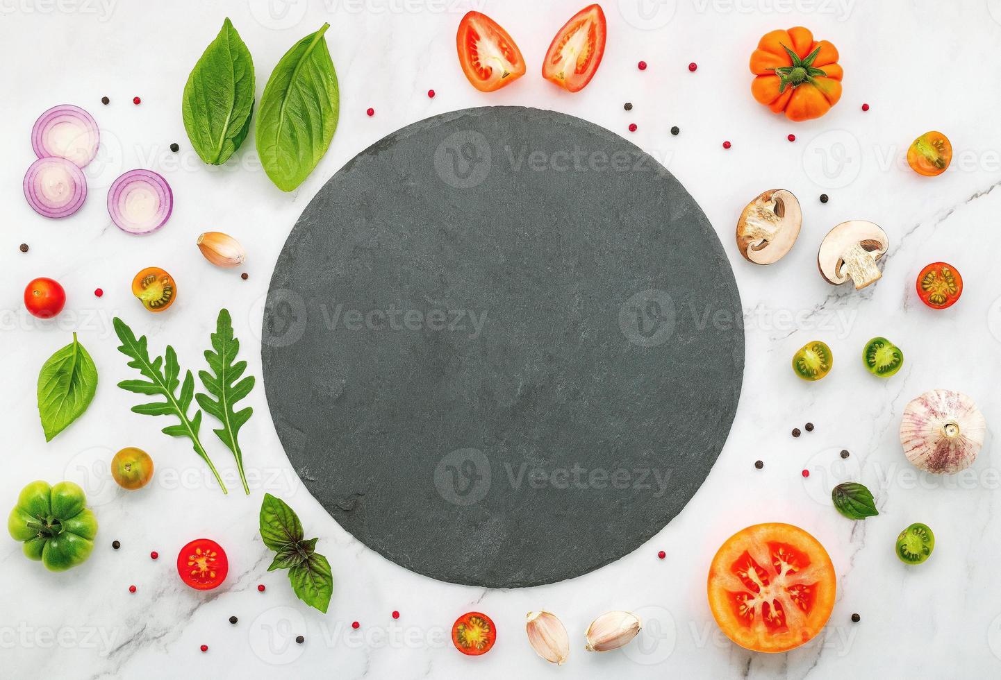 The ingredients for homemade pizza set up on white marble background photo