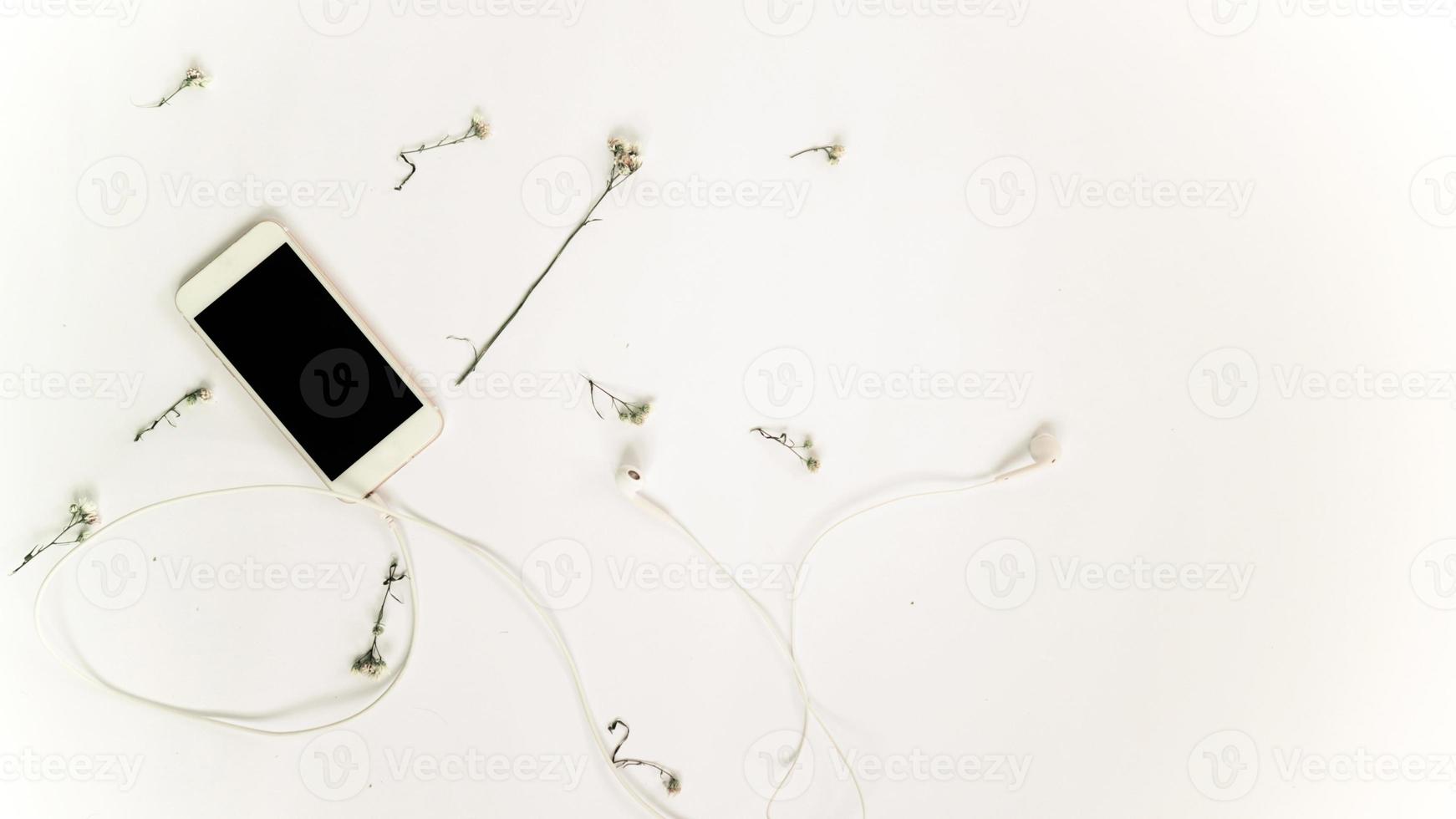 vista superior del teléfono inteligente y flor con auricular foto