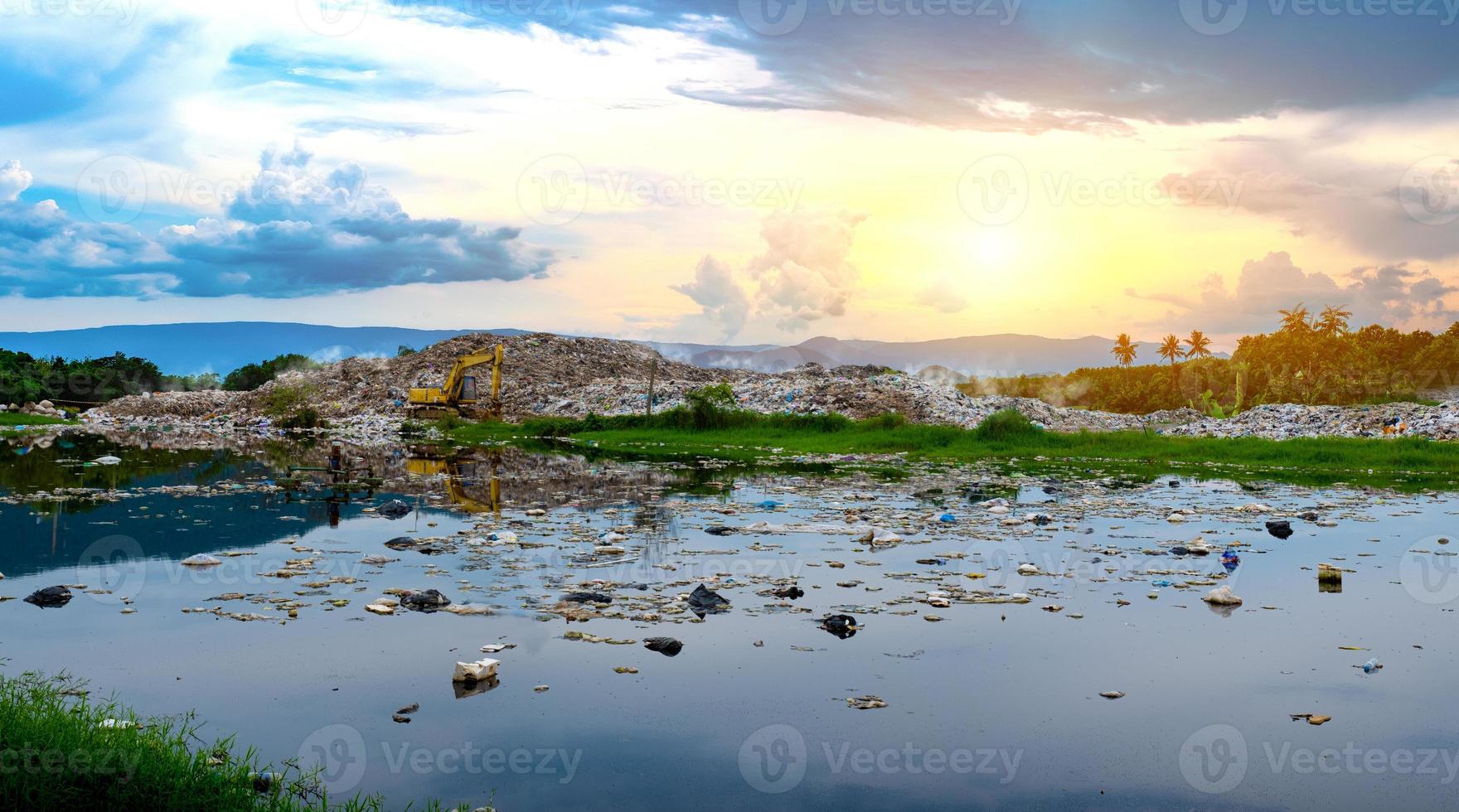 Polluted water and mountain large garbage pile and pollution photo