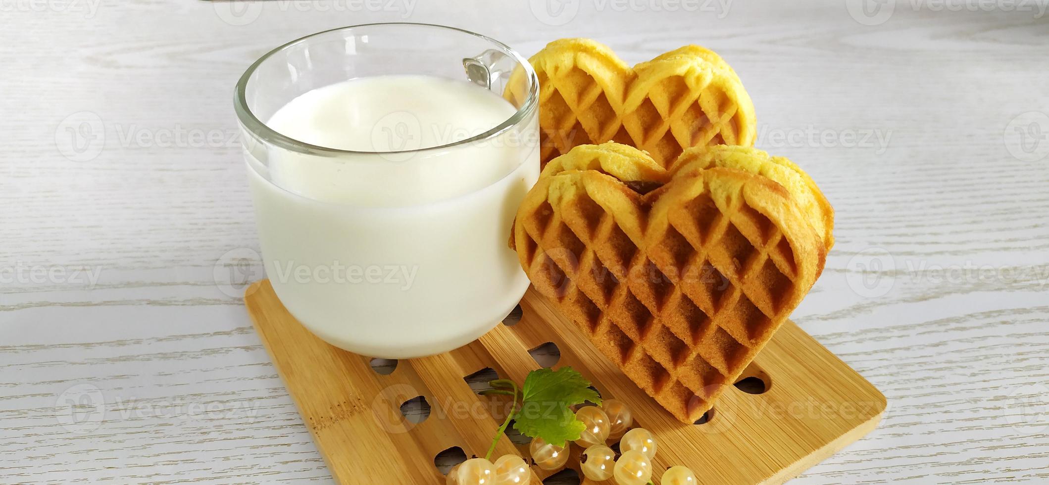 galletas corazón, leche y bayas de grosella. postre en una madera foto