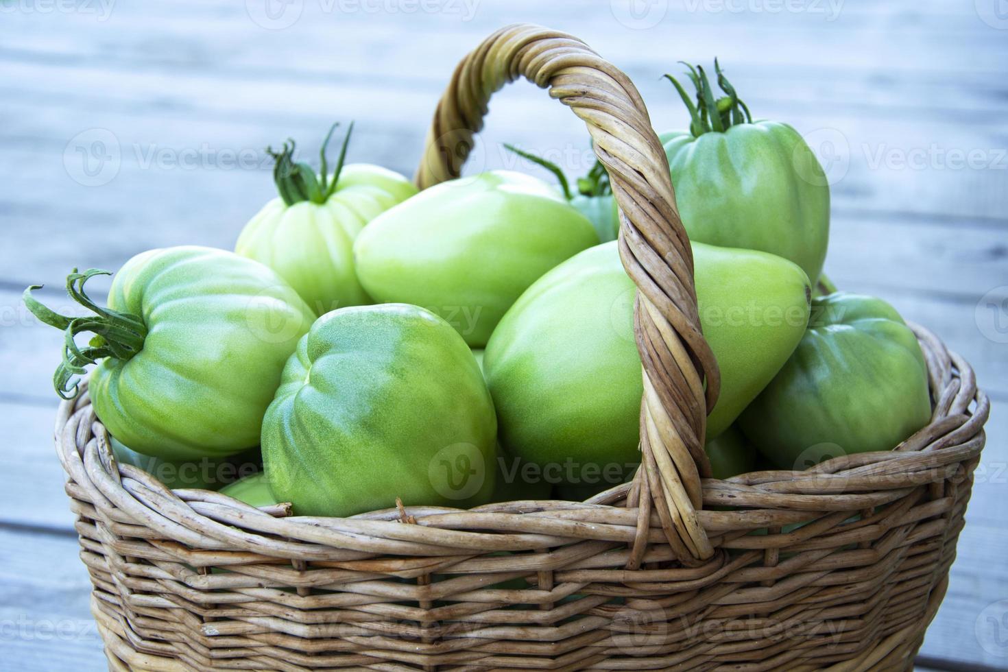 verduras en un primer plano de la cesta. una canasta de mimbre con tomates foto