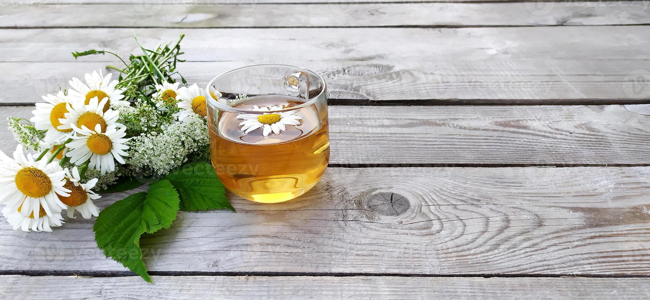 Chamomile tea and a bouquet of chamomiles photo