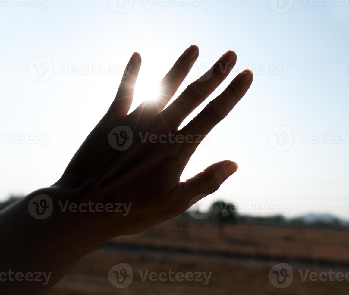 Silhouette of hand with sunset photo