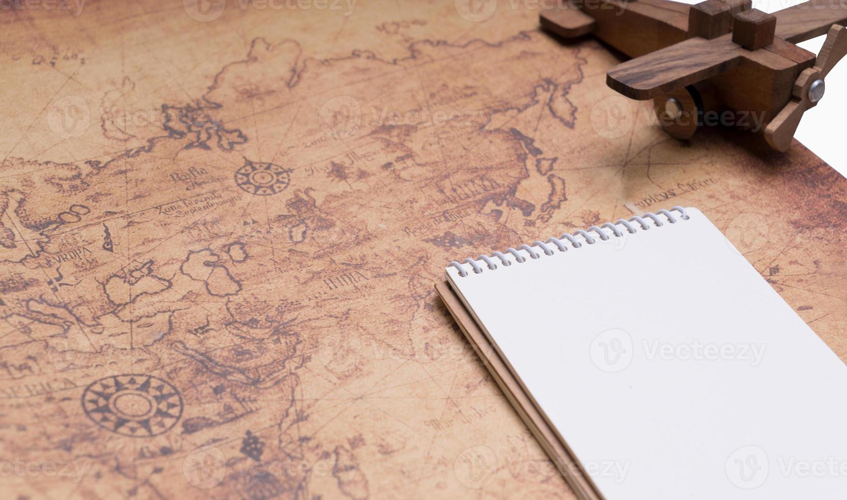 Blank notebook on retro map for travel concept photo