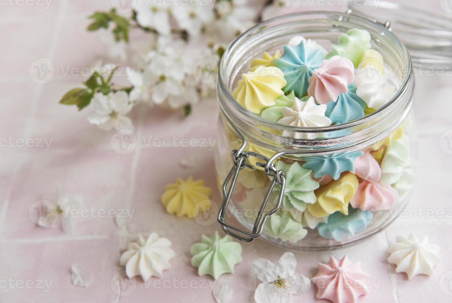 Small colorful meringues in the glass jar photo