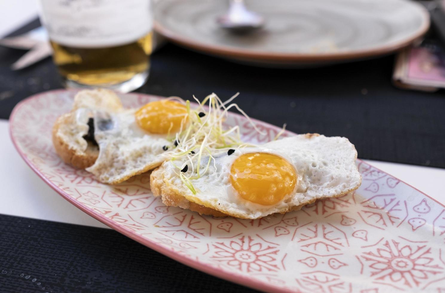 plate of fried eggs on mini crispy toast with truffle photo