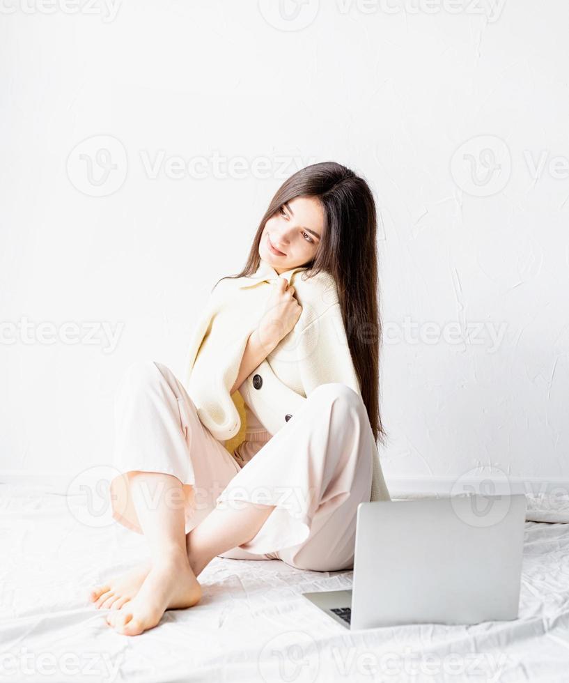 woman sitting on the floor and doing freelance project on laptop photo