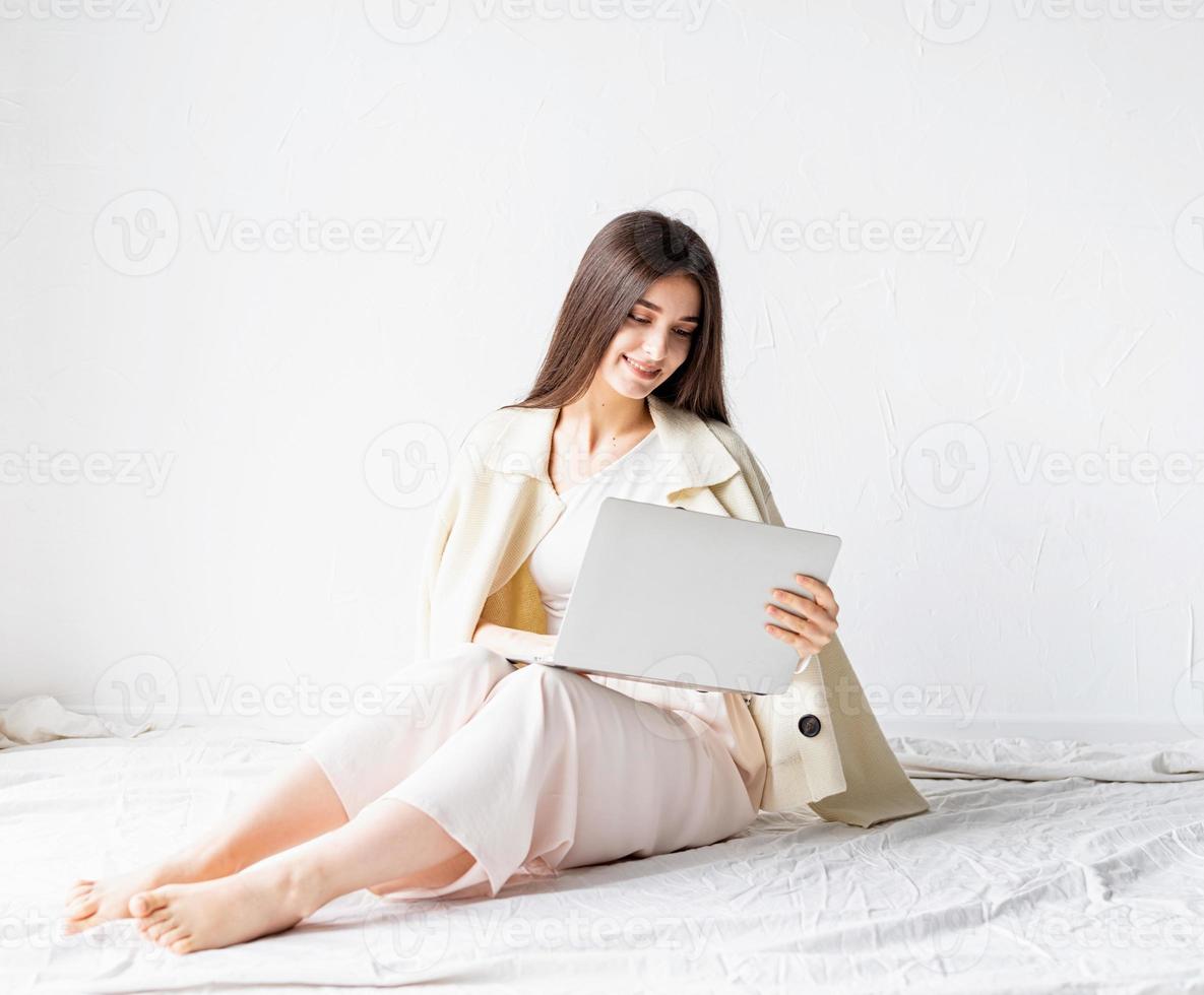 Mujer sentada en el suelo y haciendo un proyecto independiente en la computadora portátil foto