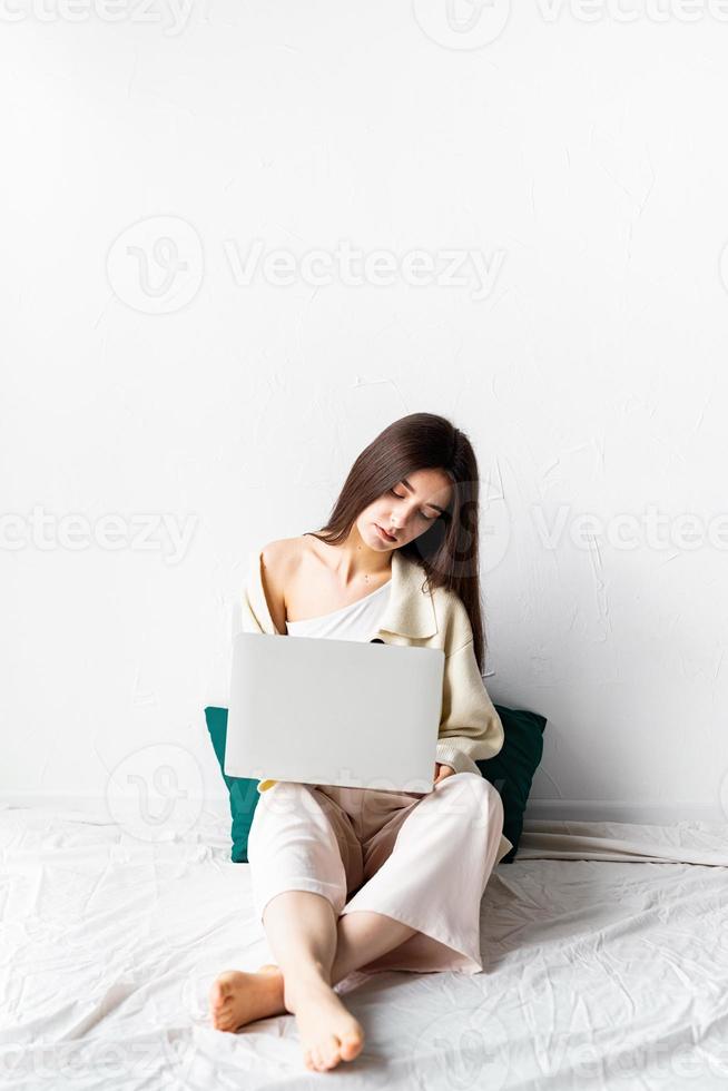 woman sitting on the floor and doing freelance project on laptop photo