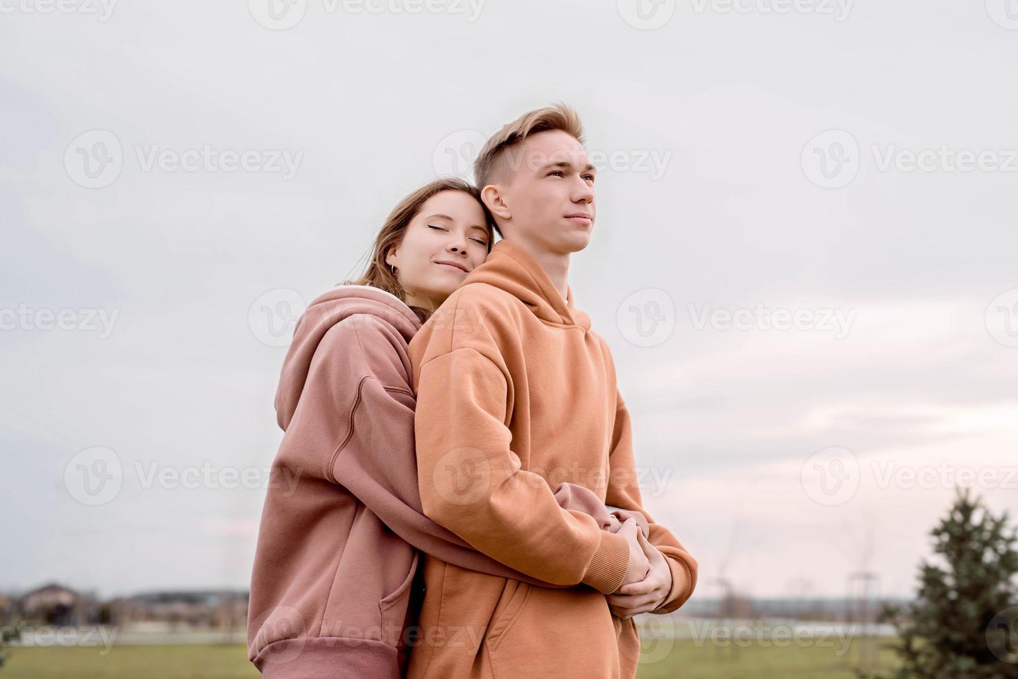 Joven pareja amorosa abrazándose al aire libre en el parque foto