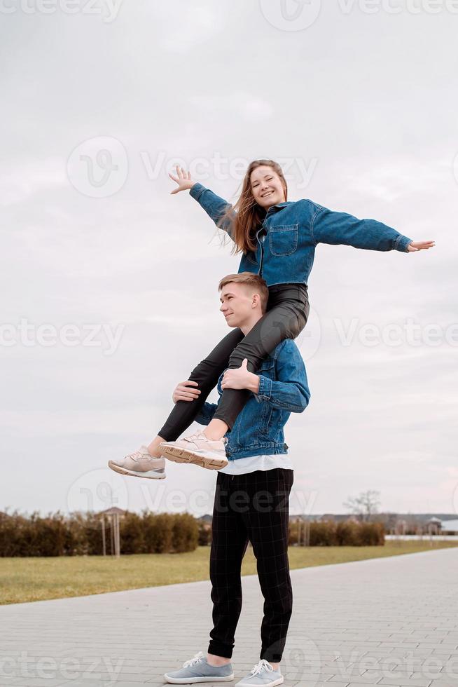 Young loving couple spending time together in the park having fun photo