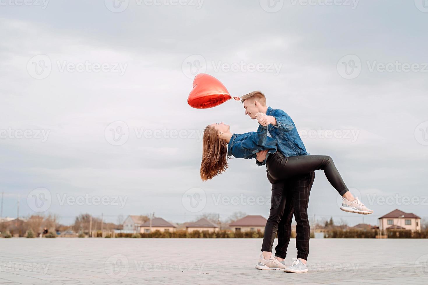 young couple dancing passionate tango on the square in the park photo
