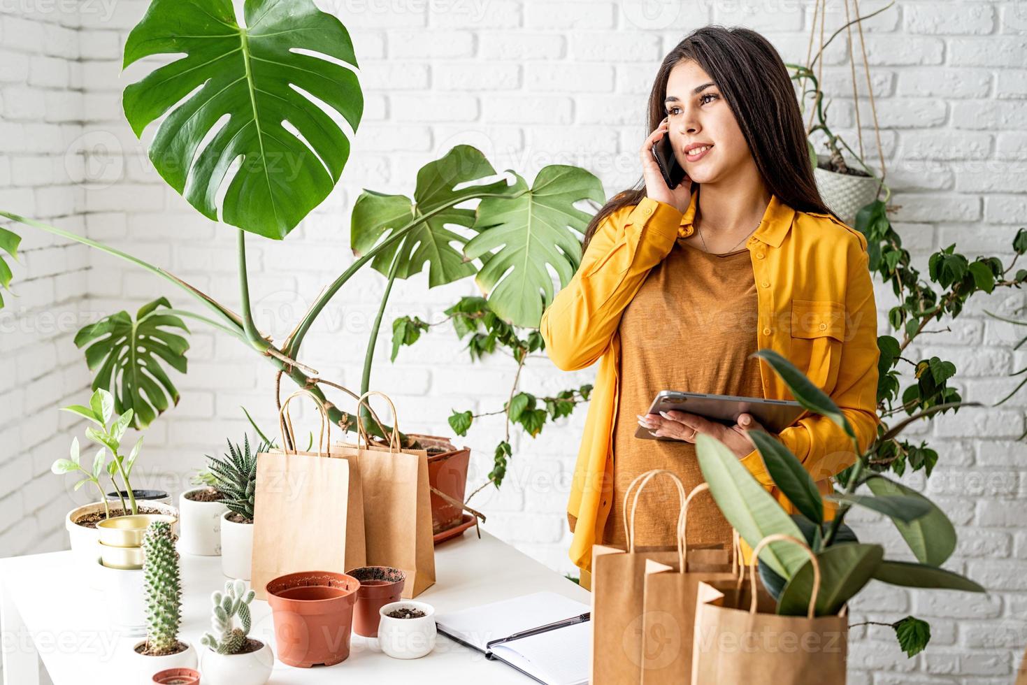 Woman gardener working on digital tablet and making a call photo