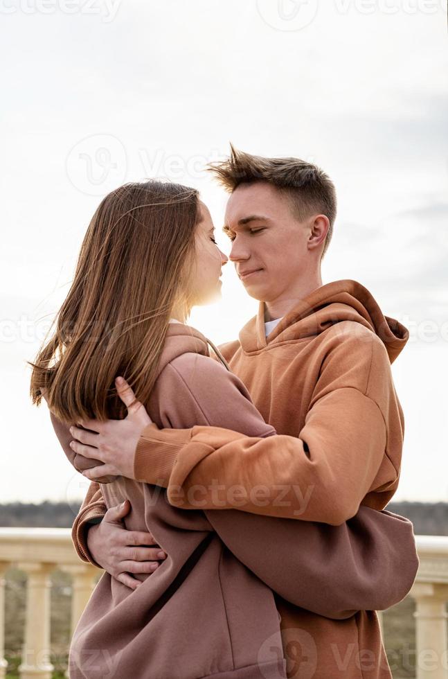 Joven pareja amorosa abrazándose al aire libre en el parque foto