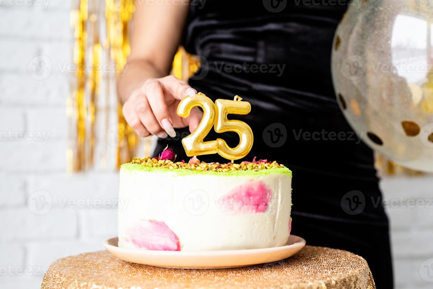 bwoman en vestido de fiesta negro celebrando su cumpleaños cortando el pastel foto