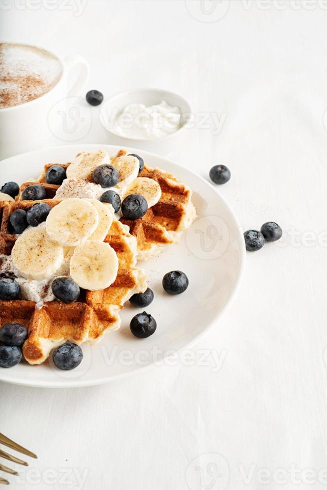 fresh made waffles with blueberries, banana and yoghurt photo