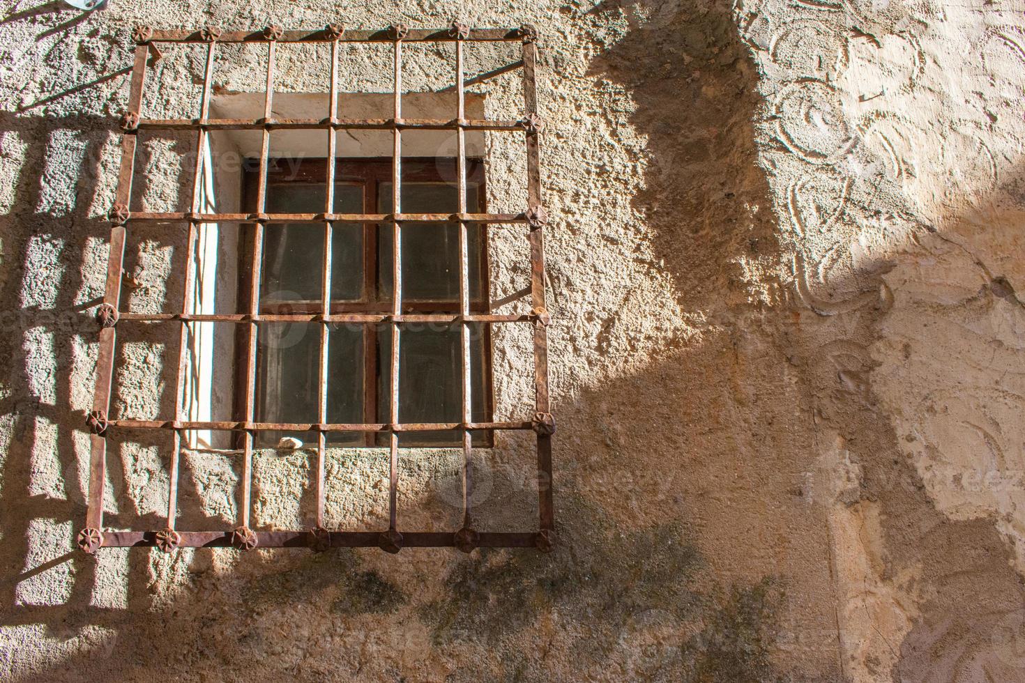 Ventana antigua con barandillas en fachada de piedra foto