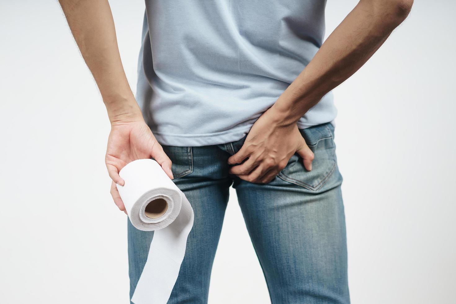 Man holding his bottom and tissue paper because Diarrhea. photo