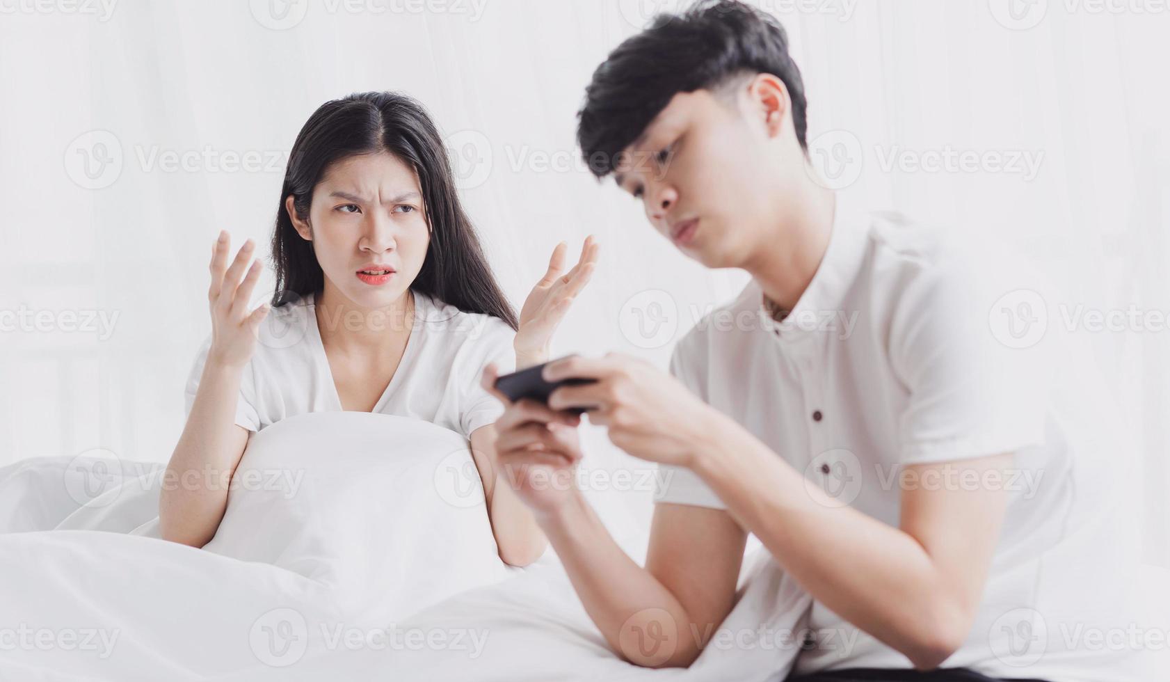 The wife is feeling upset and the husband is playing the game photo