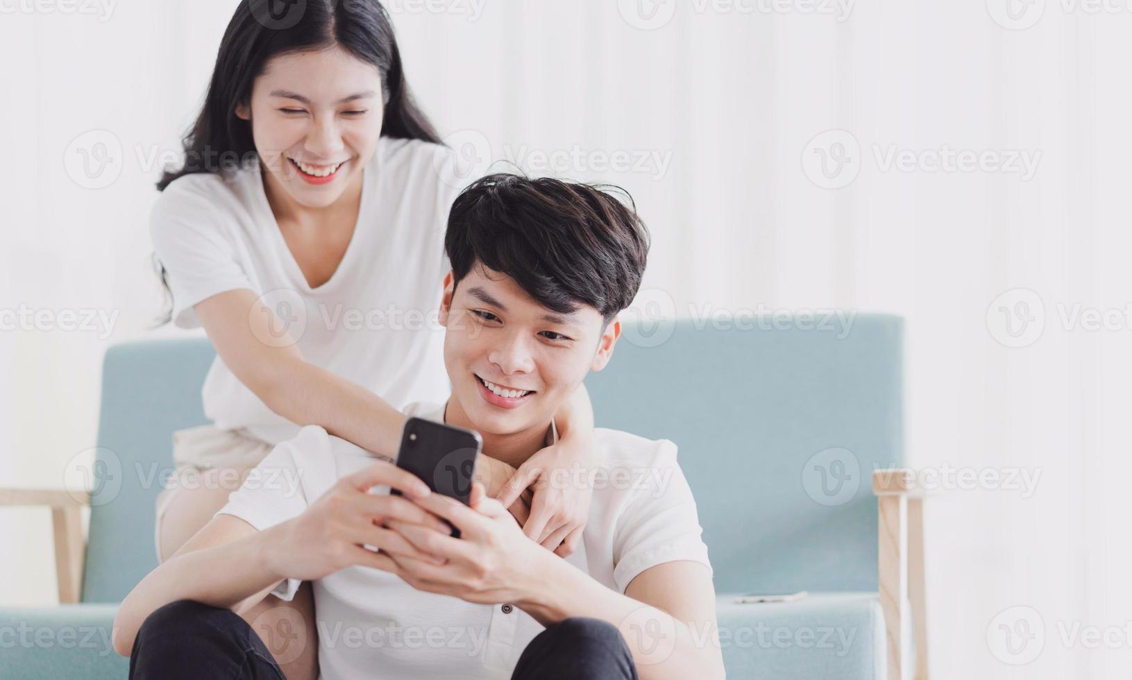 pareja joven mirando el teléfono junto con expresión feliz foto