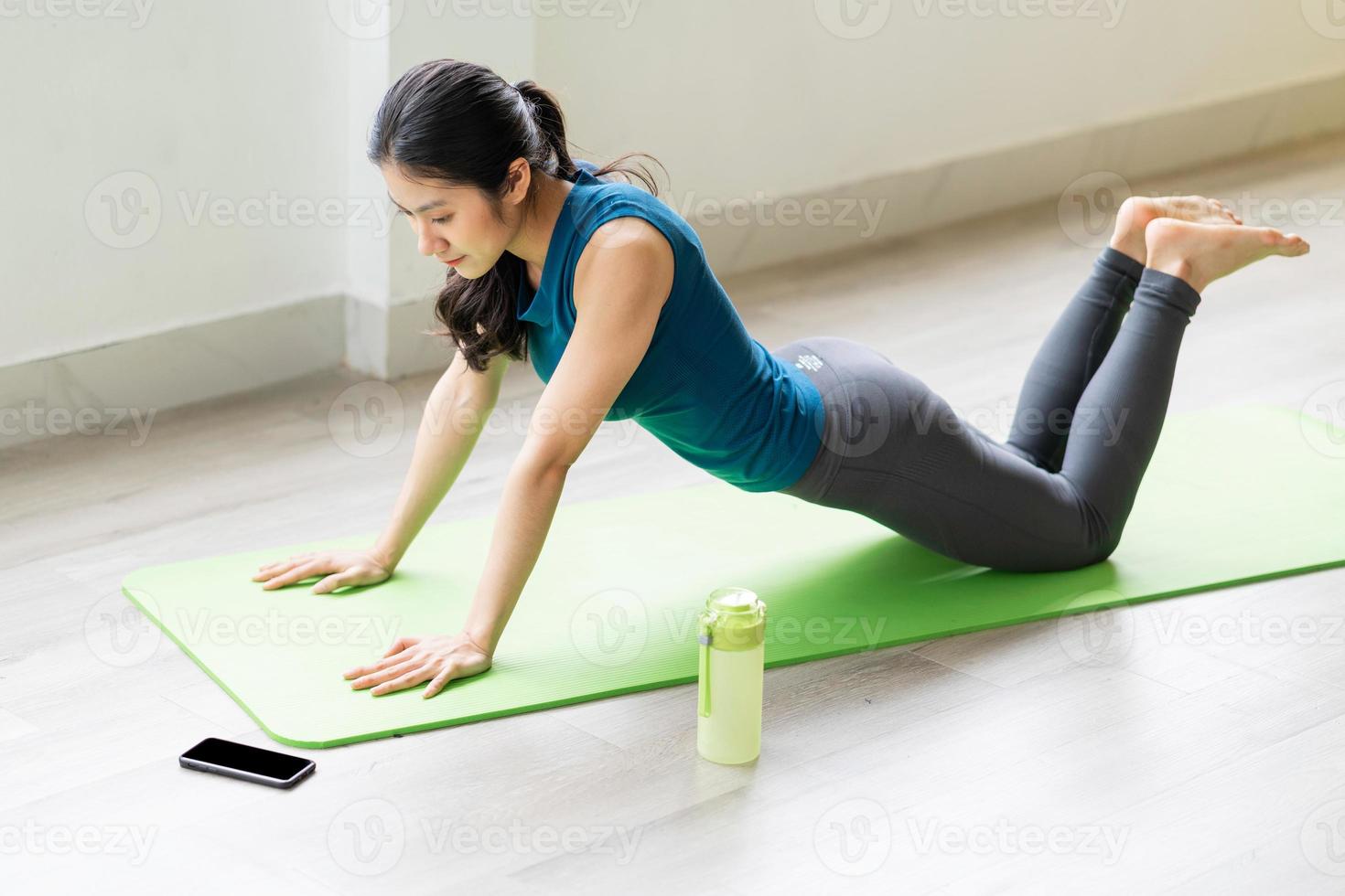 Young asian girl doing exercise on the floor alone photo