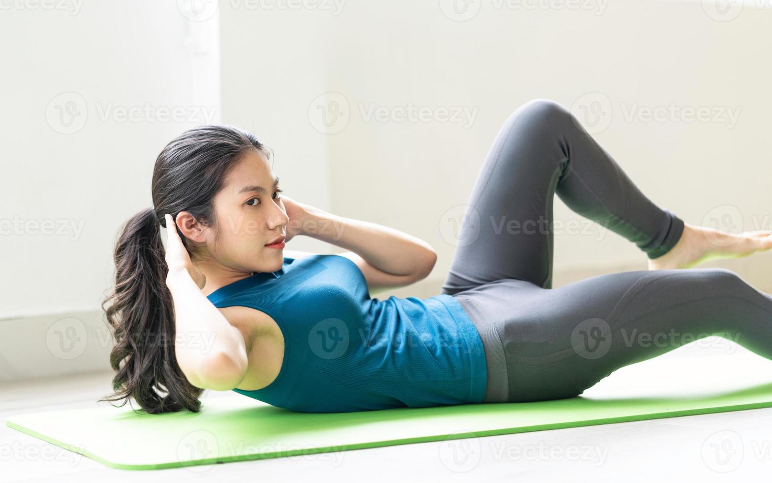 Young asian girl doing exercise on the floor alone photo