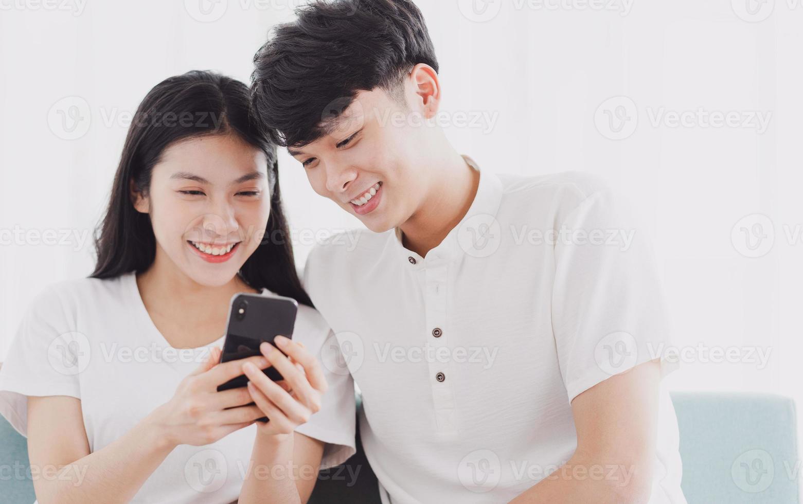 Young couple looking at the phone together with happy expression photo