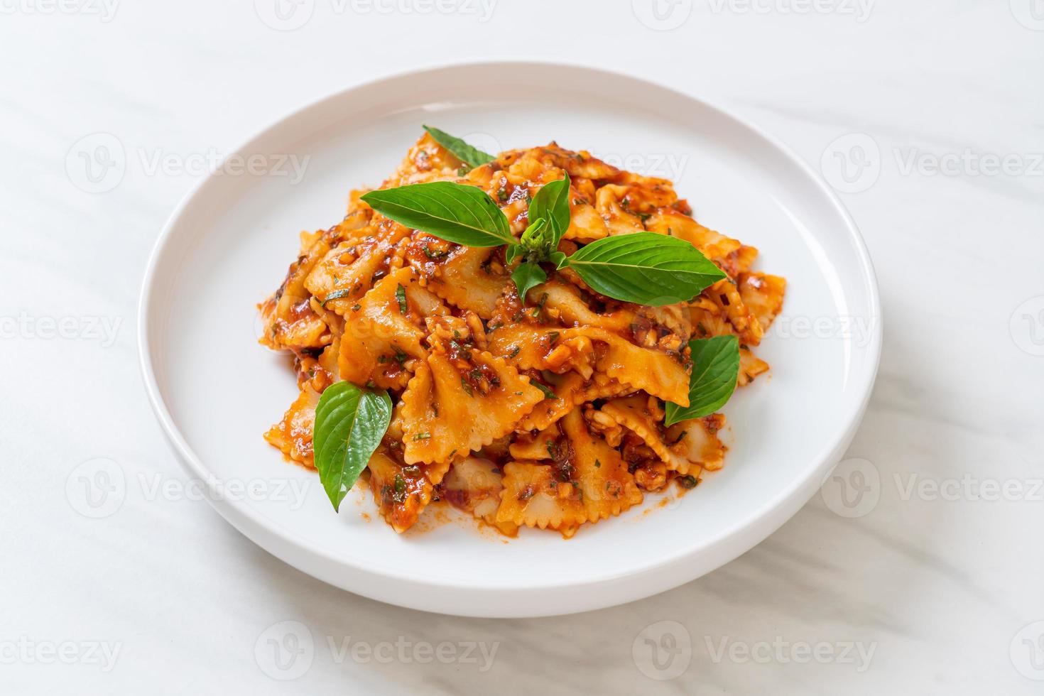 pasta farfalle con albahaca y ajo en salsa de tomate - salsa italiana foto