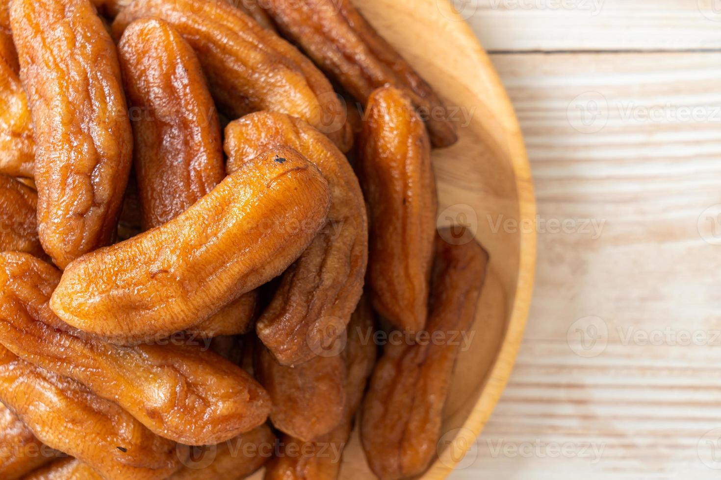 Sun-dried banana on wooden plate photo