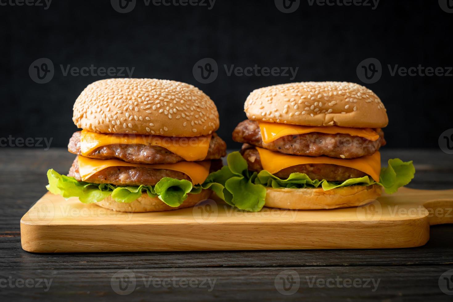 Hamburguesa de cerdo o hamburguesa de cerdo con queso sobre tabla de madera foto