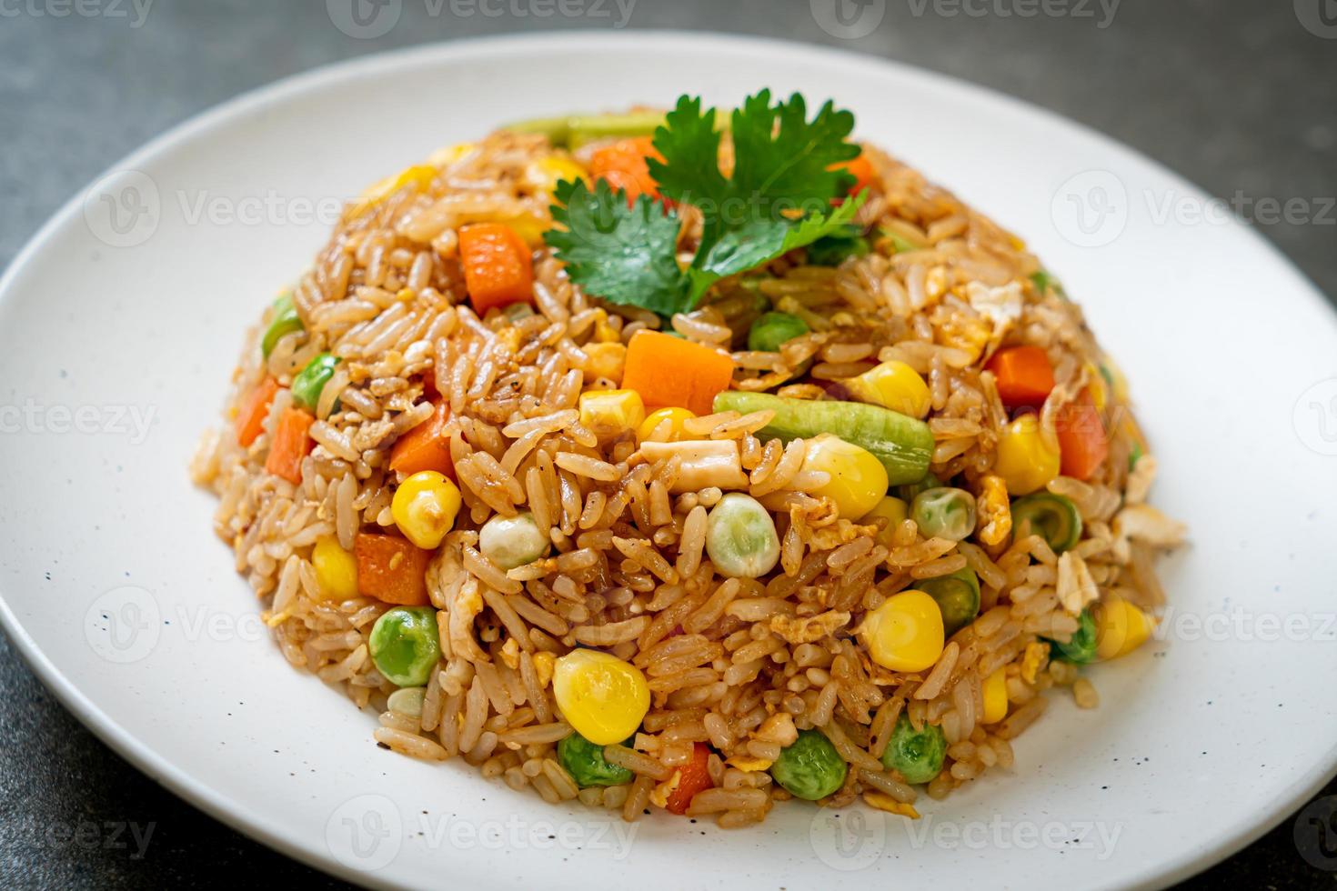 arroz frito con guisantes, zanahoria y maíz - estilo de comida vegetariana y saludable foto