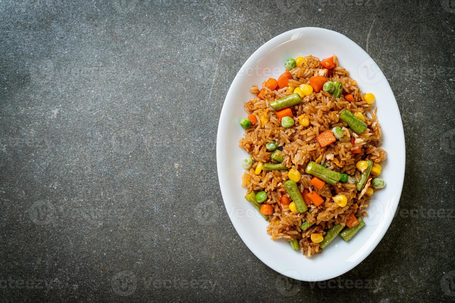 arroz frito con guisantes, zanahoria y maíz - estilo de comida vegetariana y saludable foto