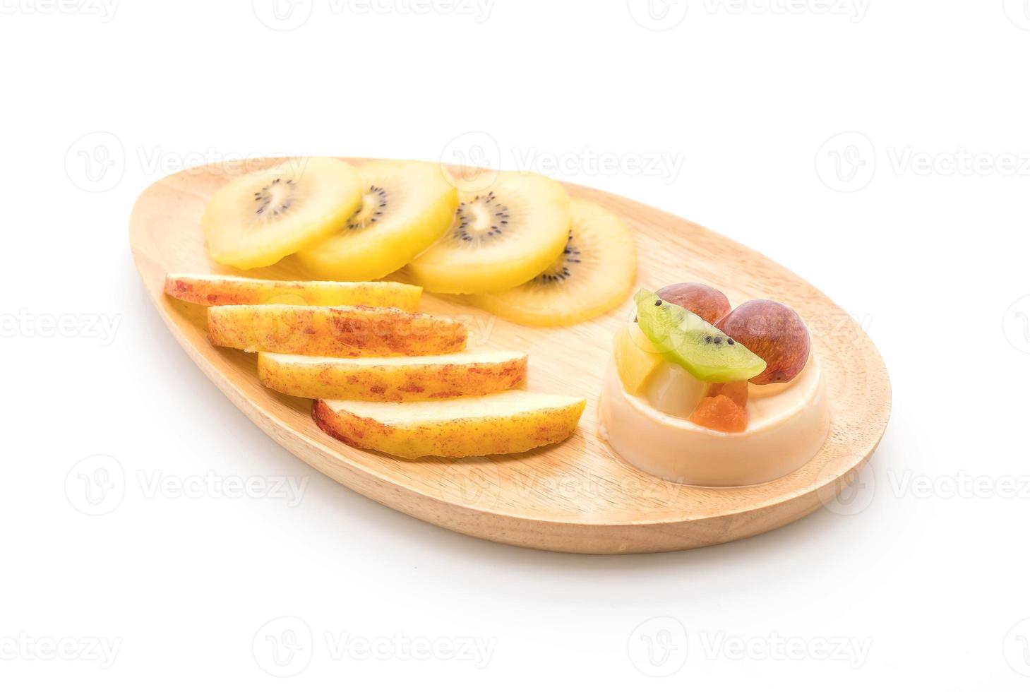 Pudín de frutas con kiwi y manzana sobre fondo blanco. foto