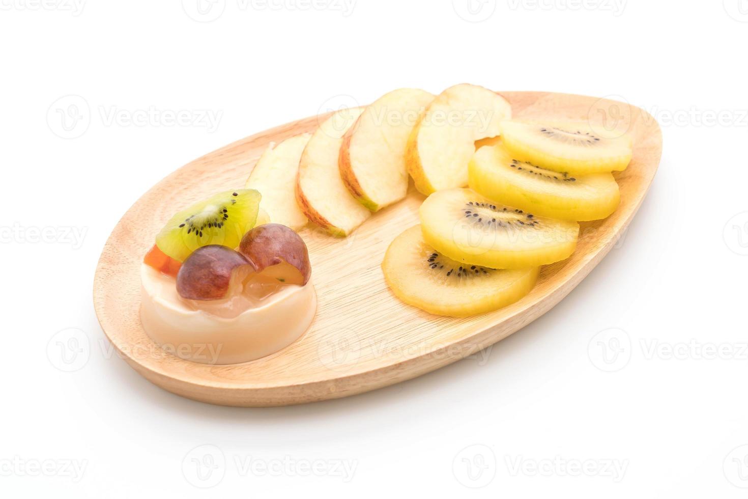 Pudín de frutas con kiwi y manzana sobre fondo blanco. foto