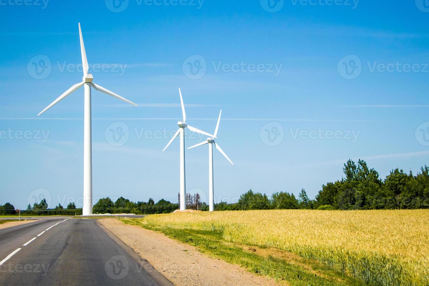 molinos de viento a lo largo de la carretera contra el cielo azul foto