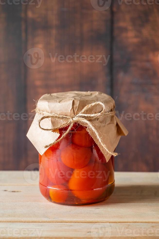 tarro con tomates fermentados sobre fondo de madera. foto