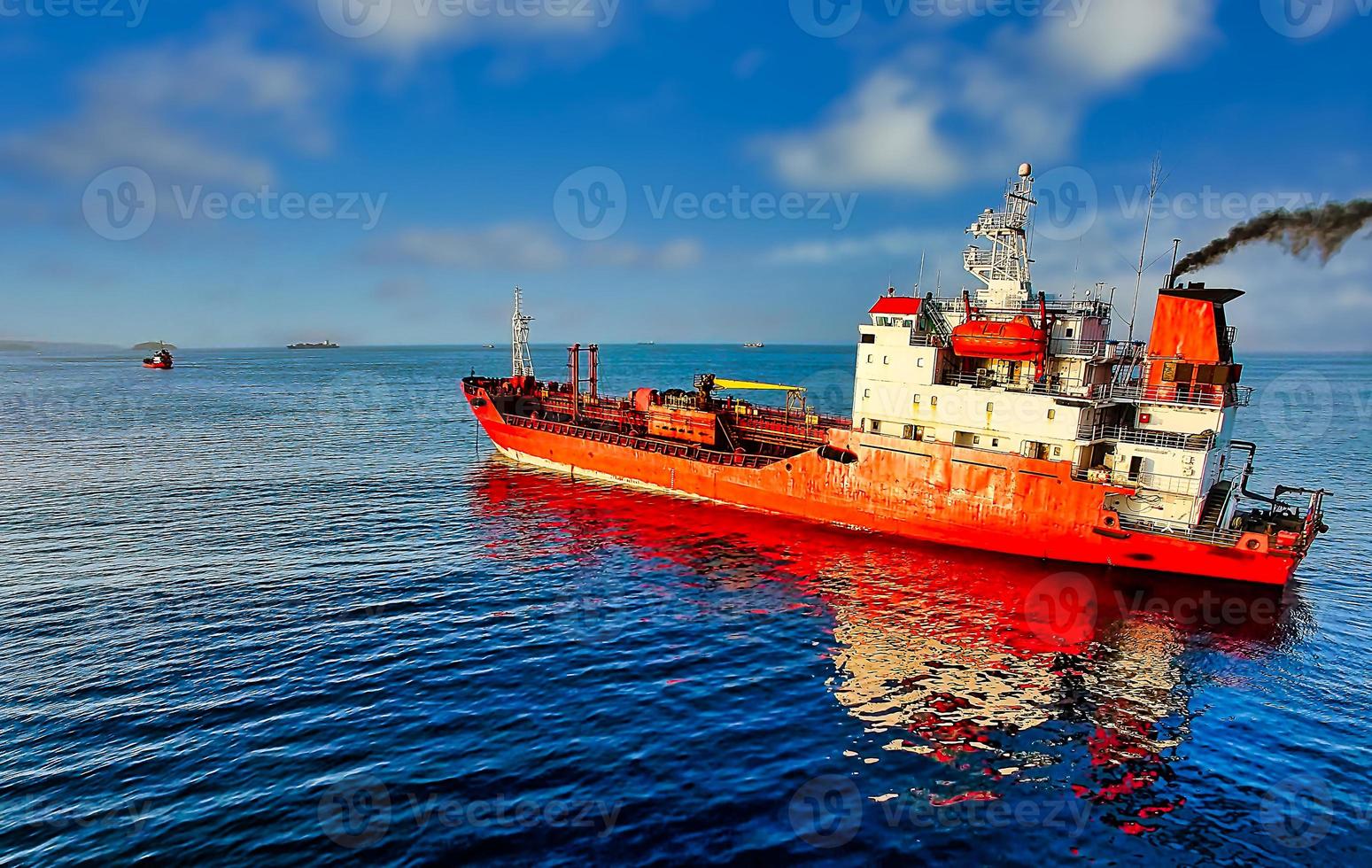 Seascape with a red ship on a blue sea background photo
