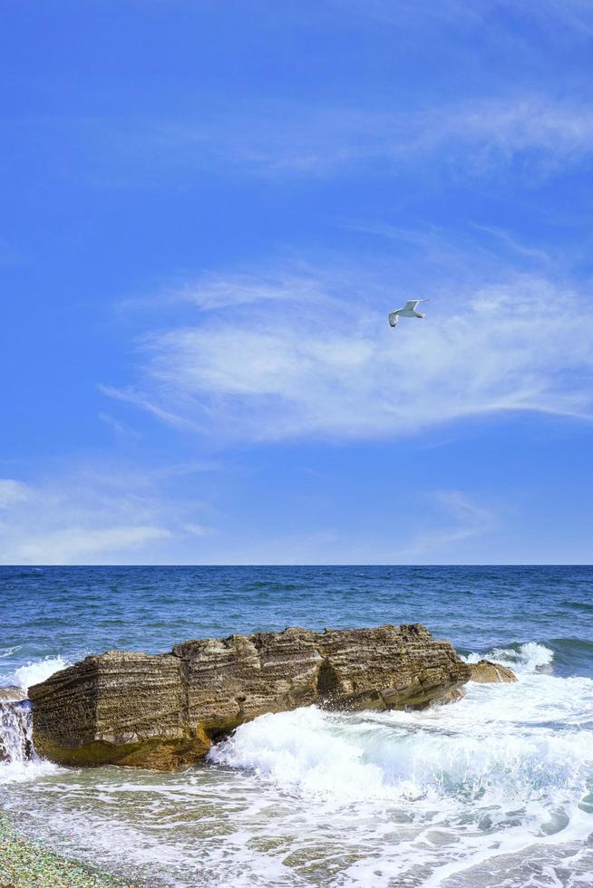 Seascape with a rock in the waves. photo
