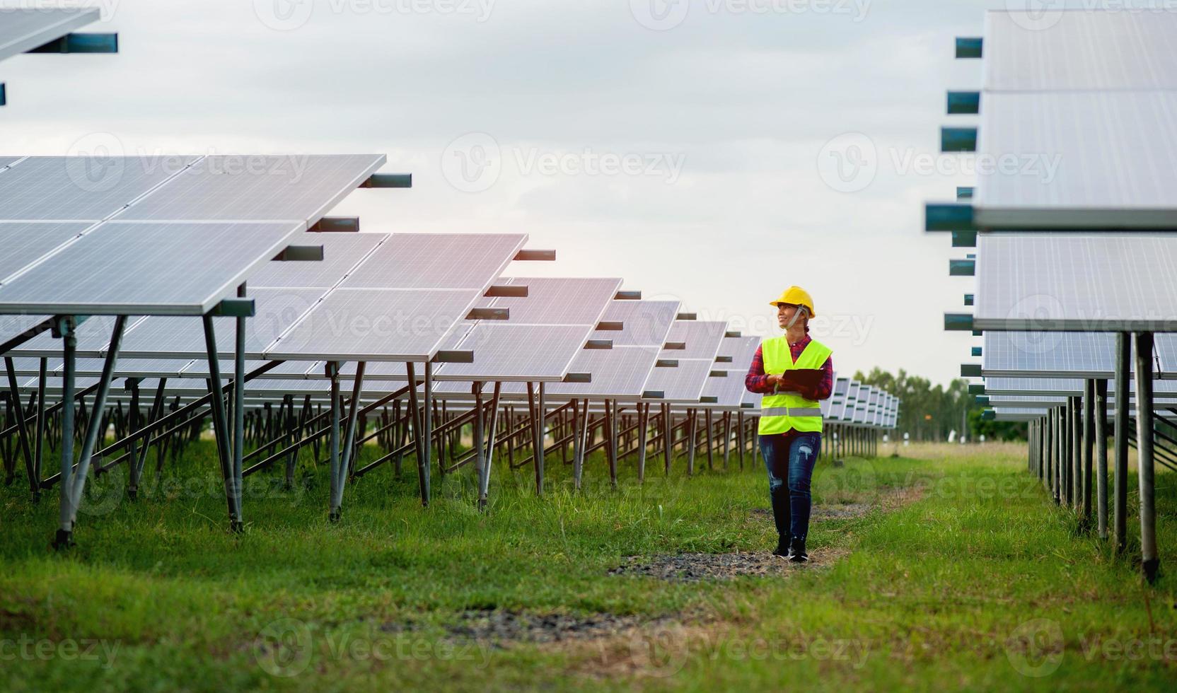 Ingeniero de sexo femenino asiático caminar inspeccionar el equipo en una energía solar foto