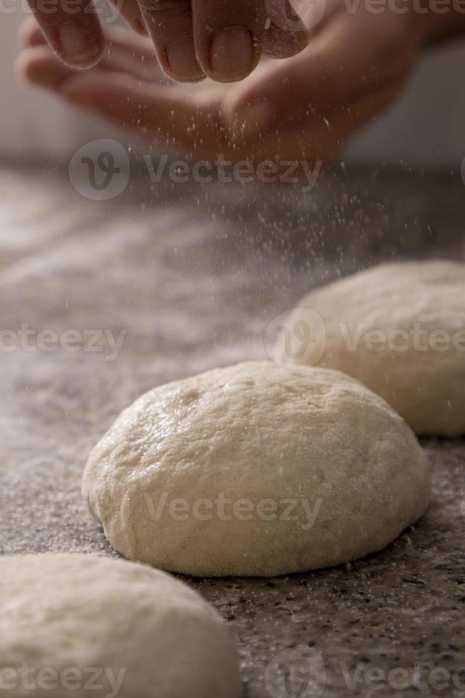 manos de mujer, espolvorear, pizza, harina, primer plano foto