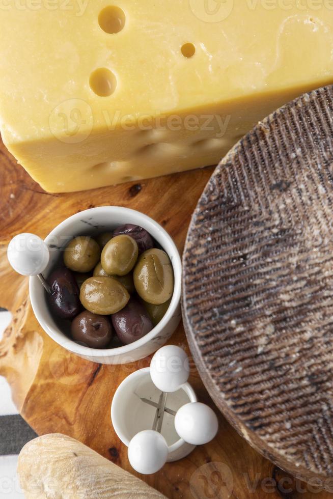 assorted cheeses platter with seasoned olives photo