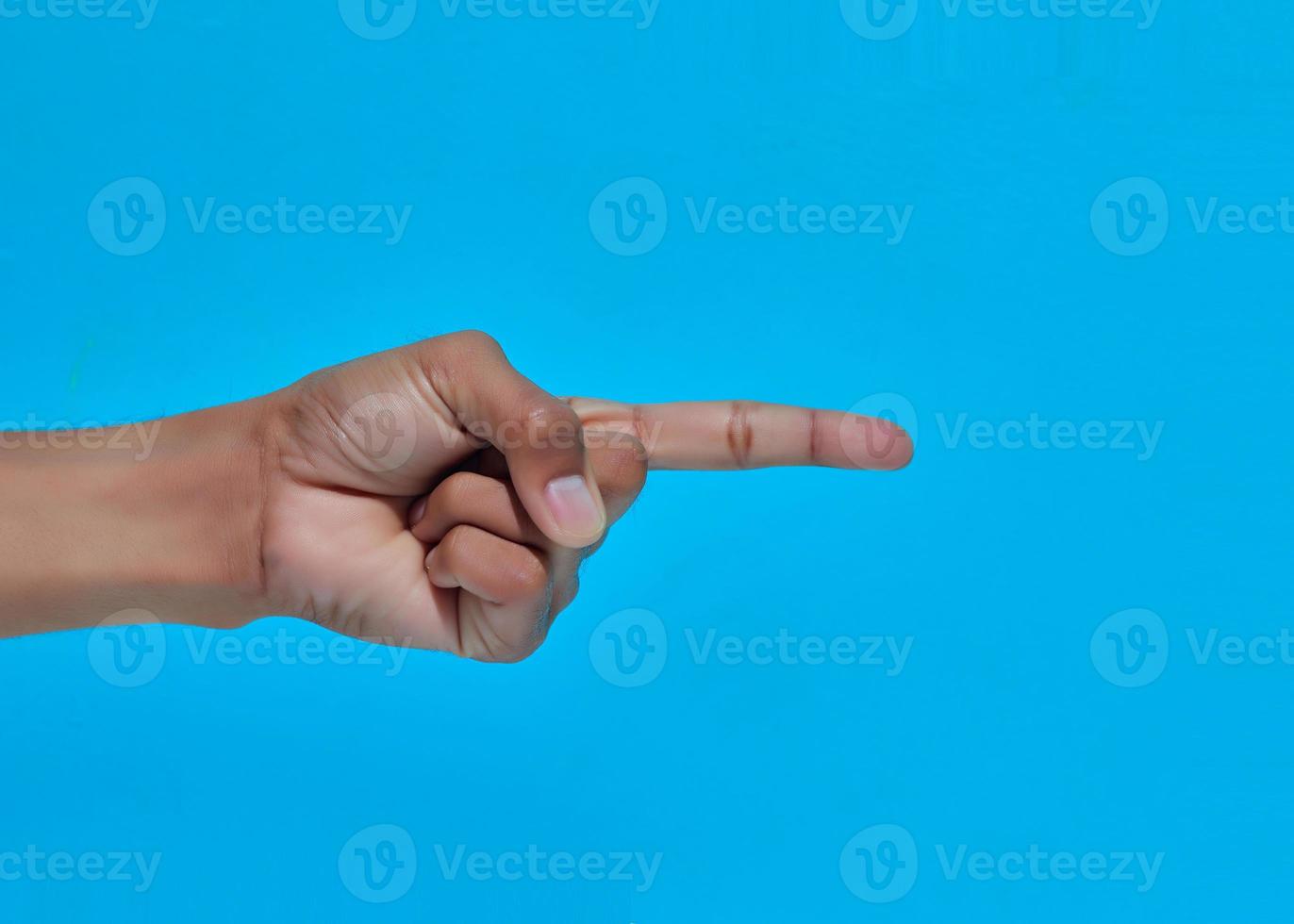 Primer plano de la mano humana mostrando o señalando o algo con el dedo. foto